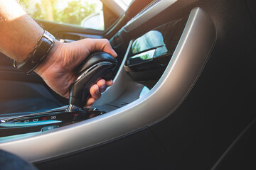 The driver's hand holds the gear lever of the automatic transmission in the car