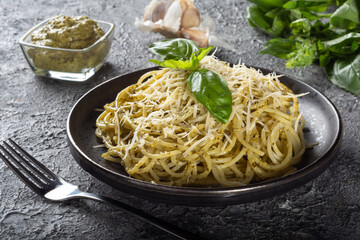 Spaghetti with Basil, Parmesan and garlic pesto. Spaghetti with Basil on a black plate.