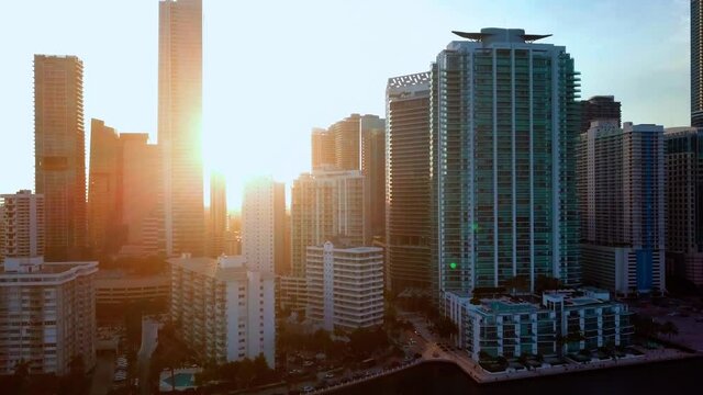 Aerial view of sunlit high rise buildings, in the Brickell skyline, during a bright, sunrise, in Miami, Florida, USA - rising, drone shot