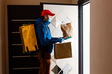 delivery man send food bag at door knob for contactless or contact free from delivery rider in...