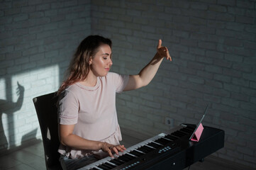 Obraz na płótnie Canvas Female singing teacher at online lesson on digital tablet