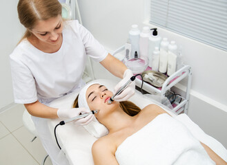 Woman getting ultrasound face beauty treatment in medical spa cente
