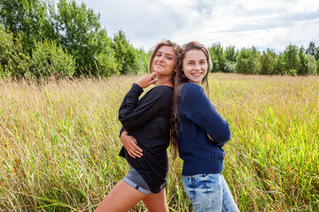 Summer holidays vacation happy people concept. Group of two girl friends dancing hugging and having fun together in nature outdoors. Lovely moments best friend.