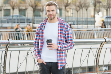 handsome young man wear headphones. casual dressed male drinking morning coffee from cup. unshaven...