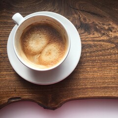 Cup of capecino on a wooden tray