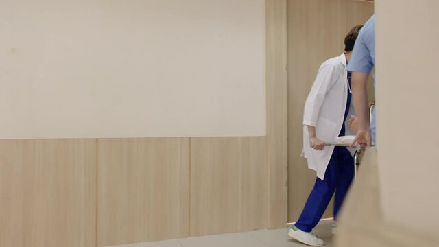 Group of young asian doctors, nurse and staff push stretcher at hallway corridor hospital with unconscious patient on bed full facility in paramedic health care medical concept.
