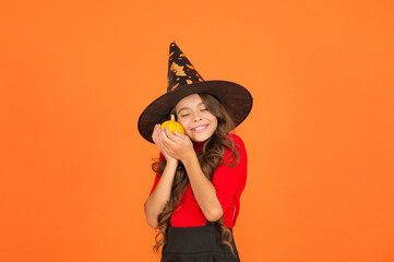 favorite food. trick or treat concept. carnival festive costume of witch. kid with small pumpkin. child celebrate autumn holiday. teenage girl in witch hat celebrate halloween. happy halloween