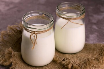 
Two jars with fresh milk on a gray background.
Close-up.