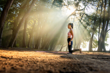 Asian woman practicing yoga and Beautiful sun rays at nature.