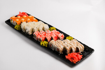 Sushi Set sashimi and sushi rolls served on stone slate. Top view. on a white background