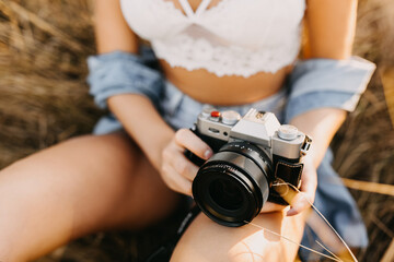 Woman holding a digital camera outdoors, closeup.