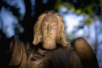 Guardian angel against dark background. (fragment of an antcient statue.