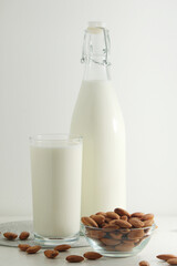 A glass with almond milk and the bowl with almonds