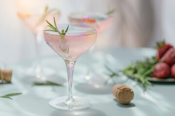A glass of strawberry cocktail or mocktail, refreshing summer drink with crushed ice and sparkling water on light blue background. Beverage photography.