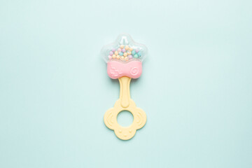 Cute baby rattle with teether on light blue background