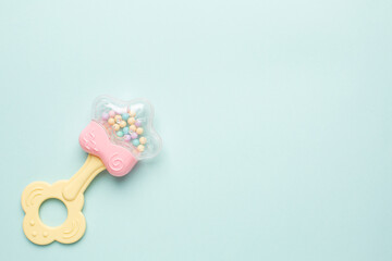 Cute baby rattle with teether on light blue background with copyspace