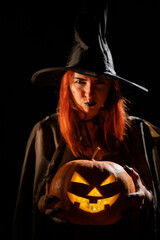 Wicked witch holding a jack-o-lantern for halloween