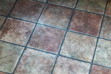 Old, dirty ceramic floor tiles. Close-up.