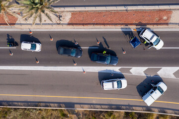 Police roadblock on a highway, with traffic progressing slowly, Aerial view.