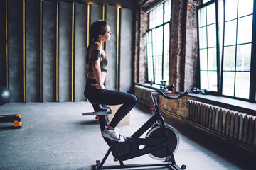 Athletic woman warming up on spin bike