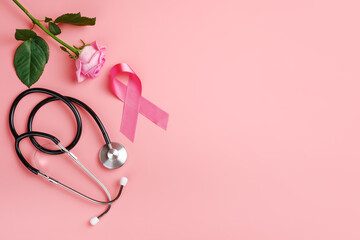 Pink ribbon, rose and stethoscope on pink background. Breast cancer awareness concept, copy space...