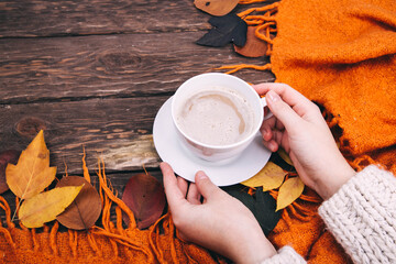 coffee, autumn leaves and a blanket on a wooden background