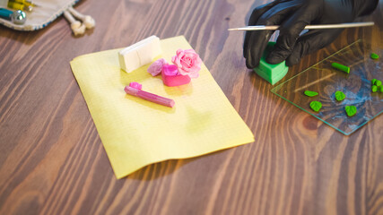 Small business concept. Professional artisan works with polymer clay at workshop.