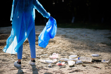 volunteering, charity, cleaning, people and ecology concept, volunteer with garbage bag cleaning area on the beach
