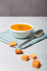 Pumpkin soup in a bowl with fresh dill herb