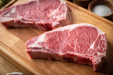 raw steak meat on cutting board in bright kitchen