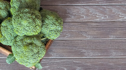 fresh broccoli heads in a wooden box top view. a copy of the space and broccoli inflorescences. background with fresh broccoli top view.