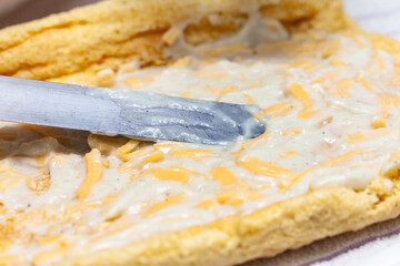 Close up of a senior woman hands stuffing a just baked sponge cake