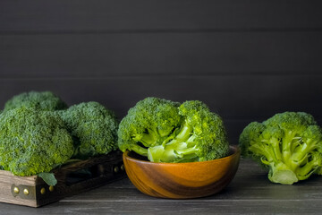fresh broccoli is on the table, in a bowl, in a wooden box. vintage broccoli on a wooden background close-up. healthy broccoli for cooking.