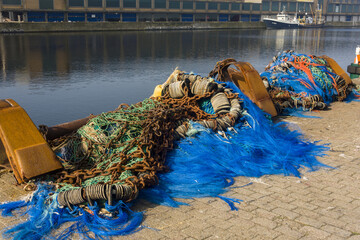 colorful nets and rusty fishing gear on a quay in the harbor of Ostend, Belgium