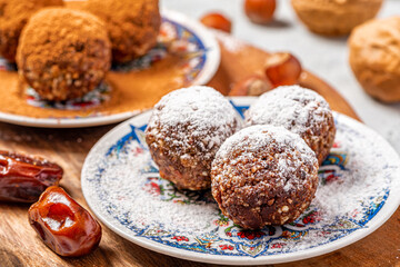 Healthy homemade paleo chocolate energy balls with nuts, dates and cocoa close-up. Homemade chocolate round candies. Sweet food with nuts.