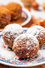 Healthy homemade paleo chocolate energy balls with nuts, dates and cocoa close-up. Homemade chocolate round candies. Sweet food with nuts.