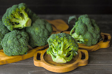 fresh uncooked broccoli in a wooden dish on the table close-up. background with fresh broccoli on a wooden background.