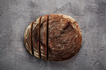 Bakery - gold rustic crusty loaves of bread and buns on grey chalkboard background.