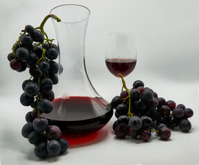 Decantador y copa de vino rodeados de uvas