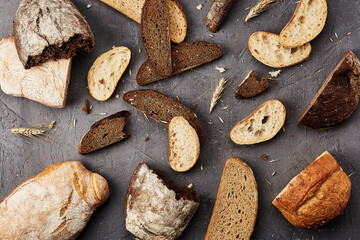 Bakery - gold rustic crusty loaves of bread and buns on grey chalkboard background.