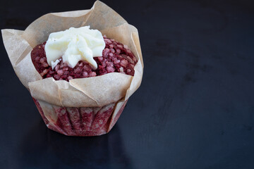 red strawberry muffin with wipped cream on a dark background. muffin with sugar. holiday background. copy space
