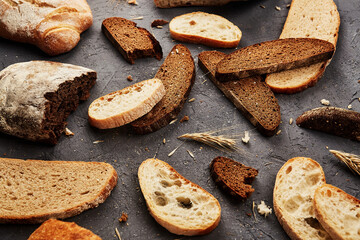 Bakery - gold rustic crusty loaves of bread and buns on grey chalkboard background.