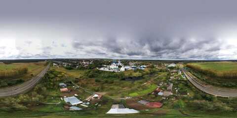 Fototapeta na wymiar a panoramic view of the old monastery of white stone with blue domes against the background of blue clouds filmed from a drone
