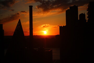 The chimney and the skyscrapers in a orange sunset