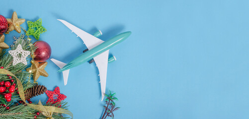 Blue background banner for travel agencies with airplane and Christmas decor with copy space