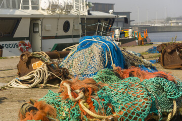 colorful nets and rusty fishing gear on a quay in the harbor of Ostend, Belgium