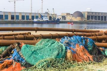 colorful nets and rusty fishing gear on a quay in the harbor of Ostend, Belgium