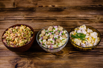 Set of festive mayonnaise salads on wooden table