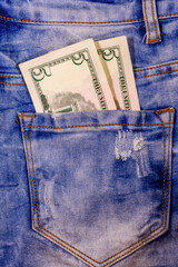 American five dollar banknotes in a pocket of blue jeans