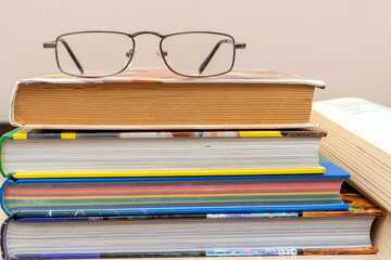 Reading glasses on a stack of books close up